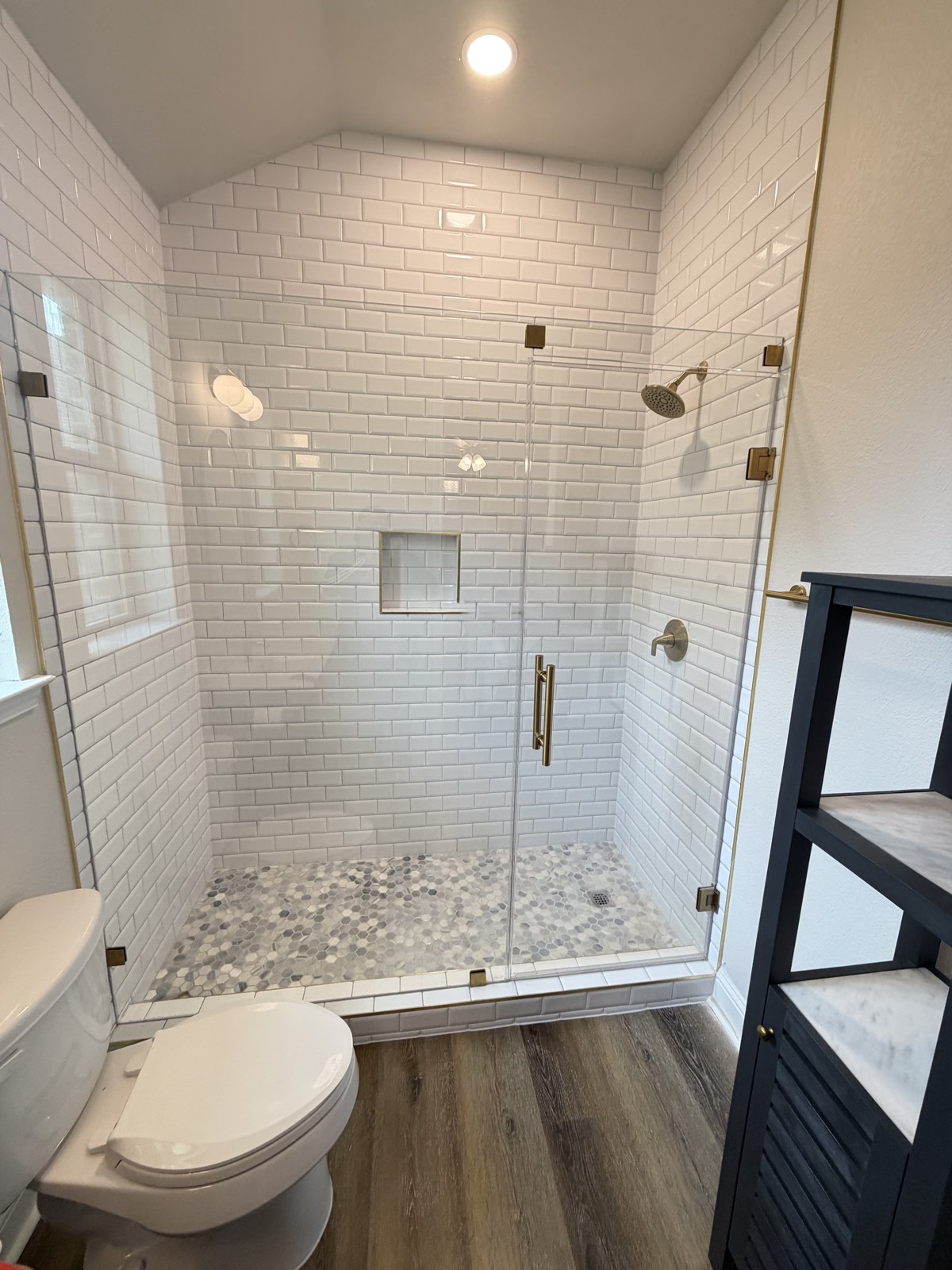 Subway tile walk-in shower with brass fixtures